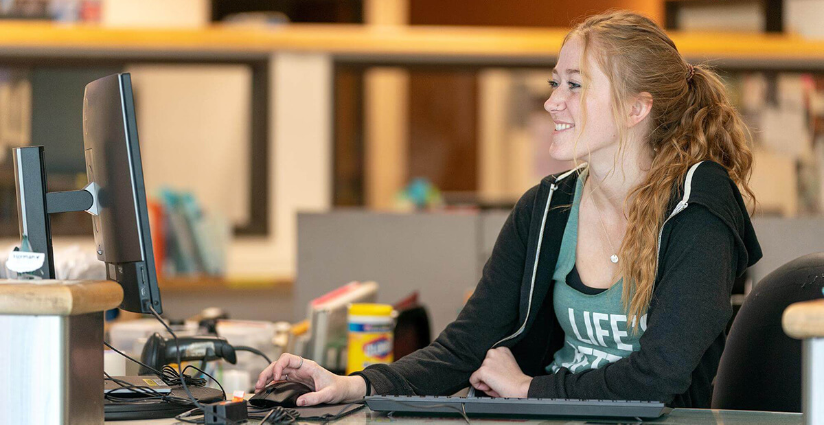 student assistant working at circulation desk